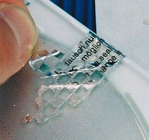 Schachbrettmuster-Effekt schützt sicher vor unerlaubten Ablöseversuchen Silber glänzende Sicherheitssiegel in länglicher Form mit spitzen Enden und Schachbrett-Effekt beim Ablösen