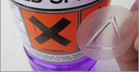 Tastbares Warnsymbol als taktiles Dreieck auf transparenten Etiketten für Verpackungen mit Gefahrstoffen
