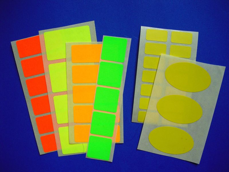 Farbige Papieretiketten aus gelbem Papier und in Neonfarben leuchtrot, leuchtgelb, leuchtgrün, leuchtorange