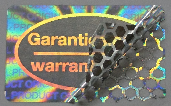 Garantiesiegel - warranty seal aus manipulationssicherer Hologrammfolie mit Wabenmuster-Zerstör-Effekt bei Ablöseversuchen