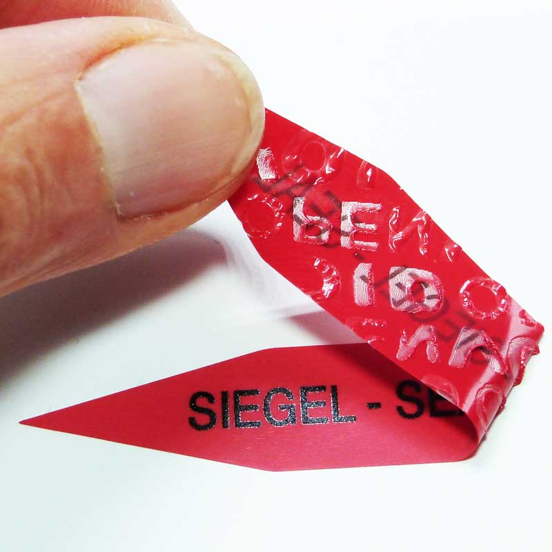 Rückstandsfrei ablösbares Siegel in Warn-Rot mit Void-Open-Effekt Rotes Sicherheitssiegel mit ablösbarem Klebstoff und Void-Open-Effekt beim Ablösen