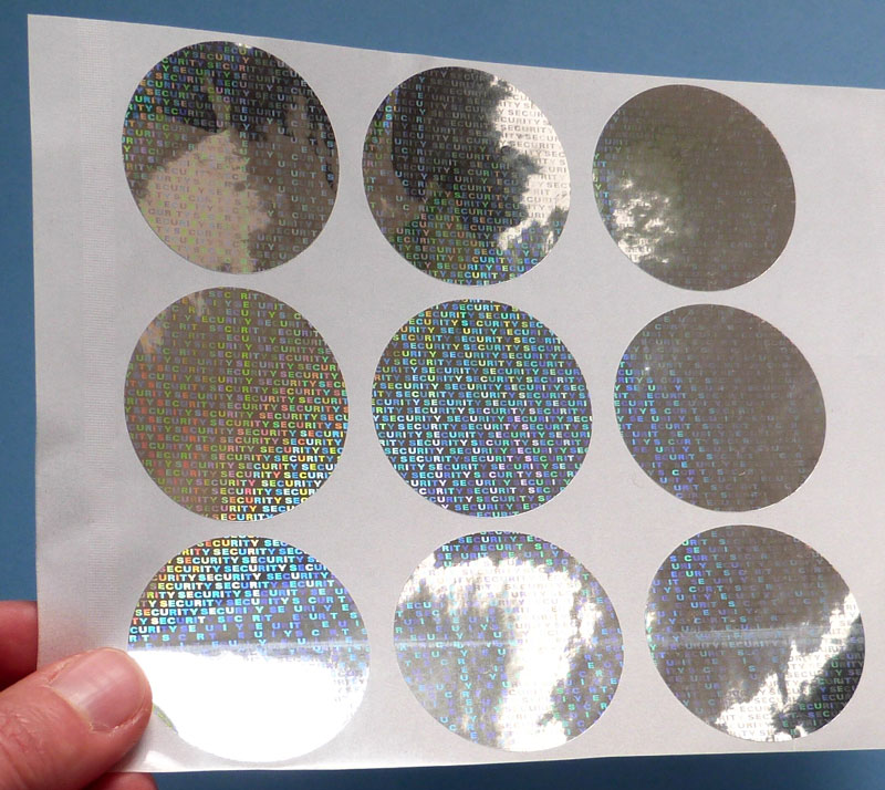 Hologrammetiketten mit Text SECURITY in runden Formaten auf Etikettenbogen
