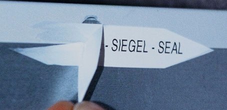 Zerstörbare Aufkleber mit dem Aufdruck SIEGEL SEAL zum Verschließen von Geräten und Verpackungen