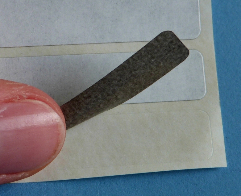 Grauer Opak-Klebstoff bei Korrekturetiketten aus weißem Papier zum Überkleben