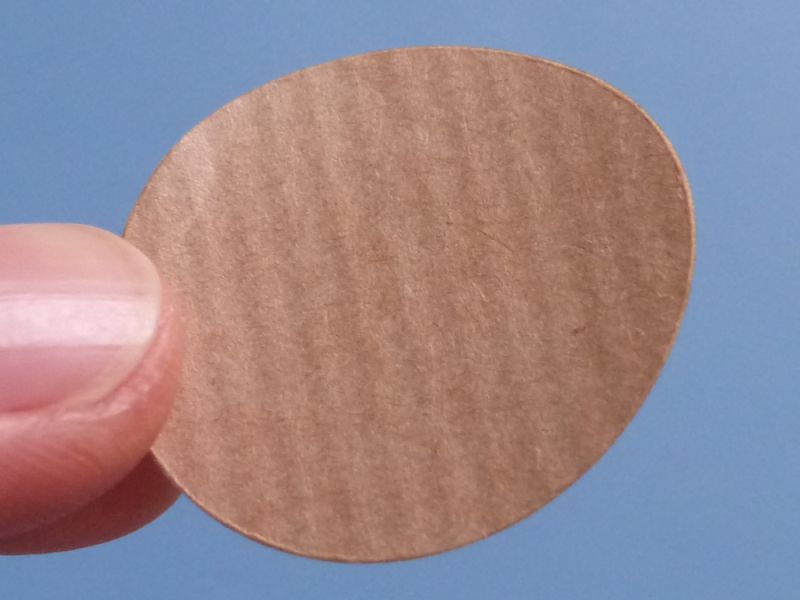 Etiketten aus Packpapier mit geriffelter Oberfläche und brauner Streifenmusterung als runde Klebepunkte 